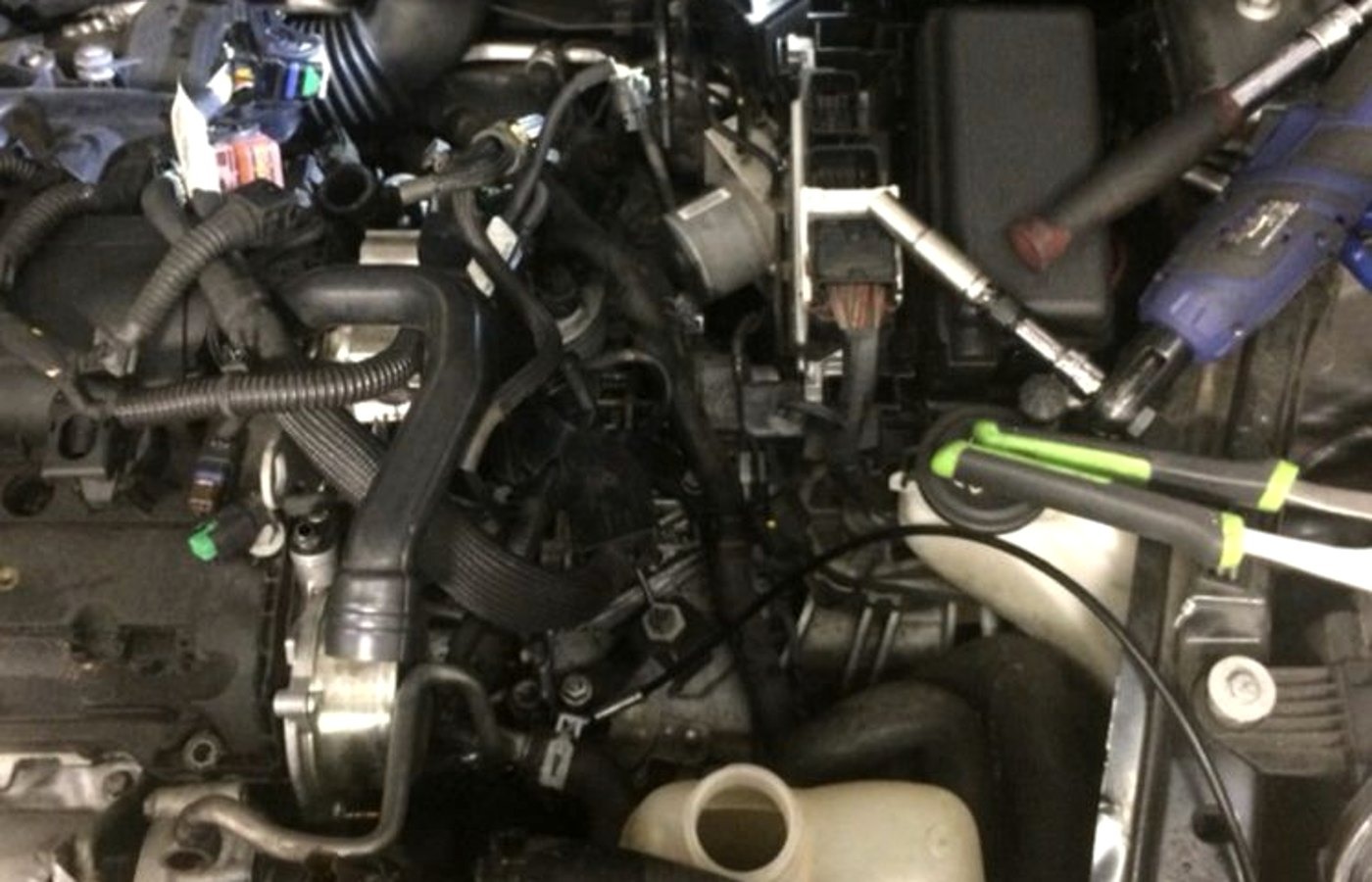 Testing deep in an engine bay during a Grand Rapids diagnostic visit